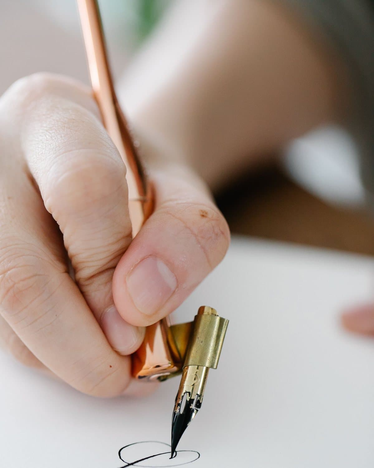 Main calligraphiant à la plume sur papier dans l'atelier