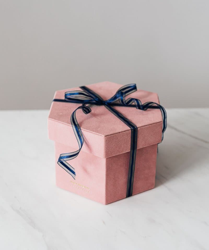 Boîte rose poudré fermée d'un ruban élégant