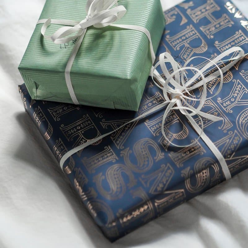 Coffrets cadeaux aux teintes vertes et bleues fermés par des rubans