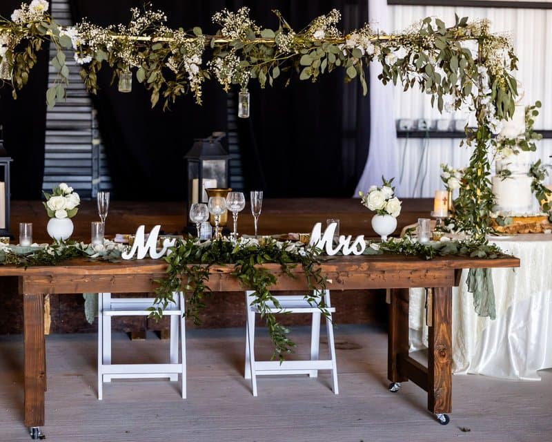 Table des mariés décorée de feuillage et de lettres Mr et Mrs